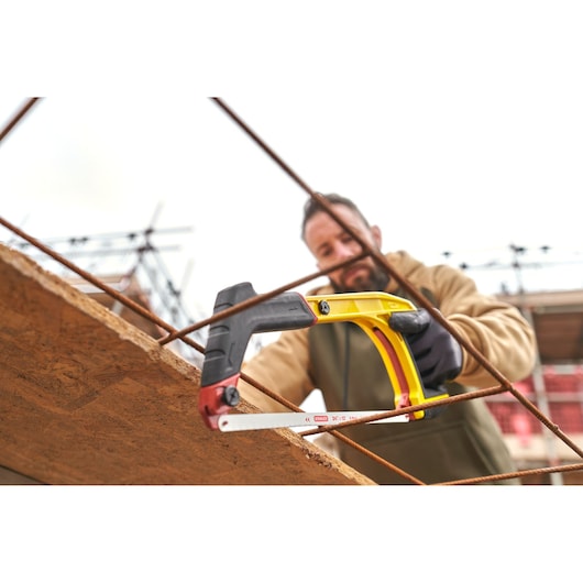 Photo of STANLEY 0-20-108 hacksaw with yellow and black handle, used on construction site.