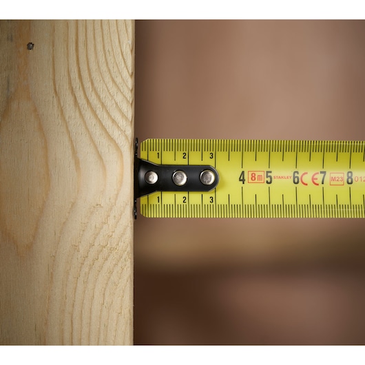 STANLEY 0-33-728 tape measure close-up on wood, yellow color with clear metric markings.