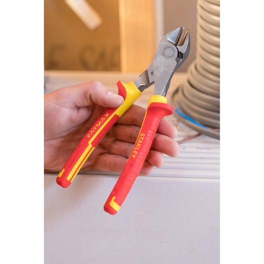 STANLEY 0-84-004 insulated side cutting pliers with red and yellow handles, held in hand.