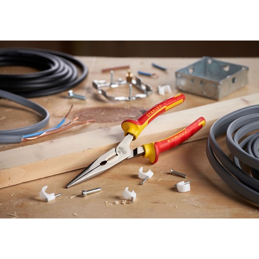 Photo of STANLEY 0-84-007 insulated long nose pliers with yellow and red handles on a workbench.