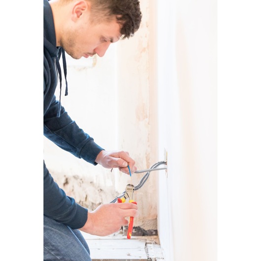 Photo of STANLEY 0-84-016 pliers used for electrical wiring repair near a wall outlet.
