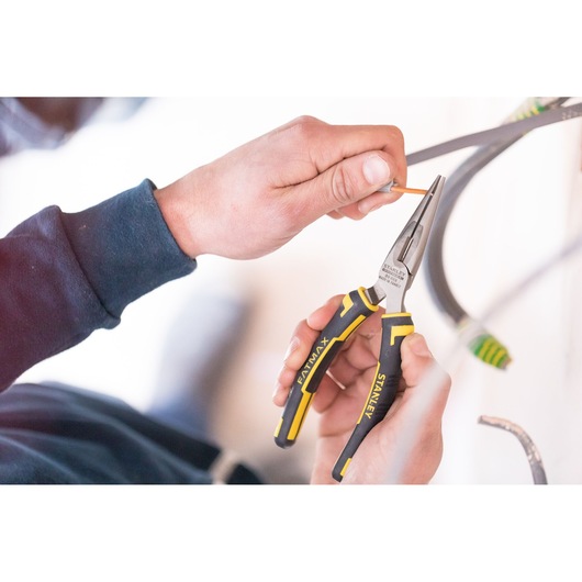 STANLEY 0-89-869 long nose pliers with yellow and black handle in use by hand, close-up photo.