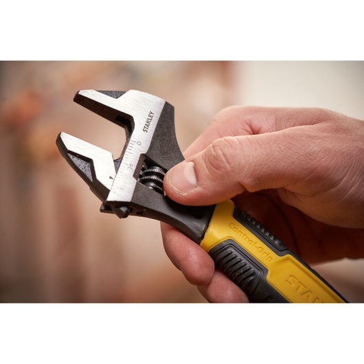 Photo of STANLEY 0-90-948 adjustable wrench with yellow and black handle held in hand.
