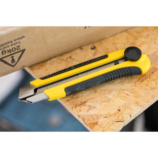 STANLEY 1-10-425 yellow and black utility knife on wooden surface, angled side view.