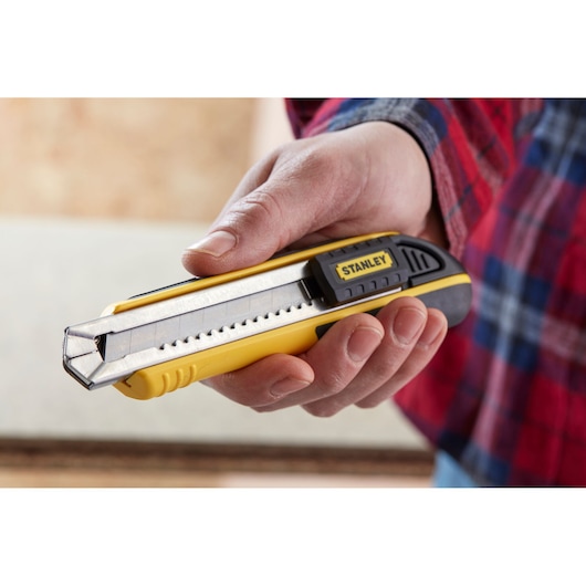 Photo of STANLEY 1-10-481 utility knife held in hand, yellow and black body with retractable segmented blade.