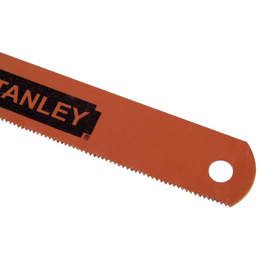 Close-up of a Stanley red saw blade with small teeth and a hole for hanging at the end.
