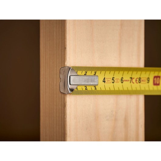 Photo of STANLEY 1-33-195 tape measure measuring a wooden plank, close-up view.