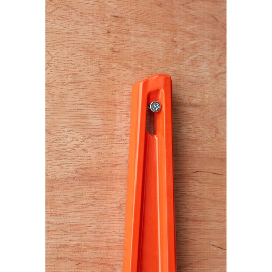 STANLEY 1-42-314 orange spirit level corner close-up photo, fixed with screw on wooden background.