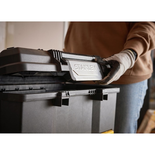 STANLEY 1-79-206 tool box photography, black box with person opening lid, side angle.