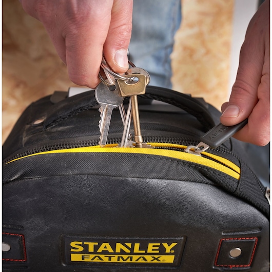STANLEY 1-79-215 tool bag close-up with keys held above yellow zipper, FATMAX logo visible.