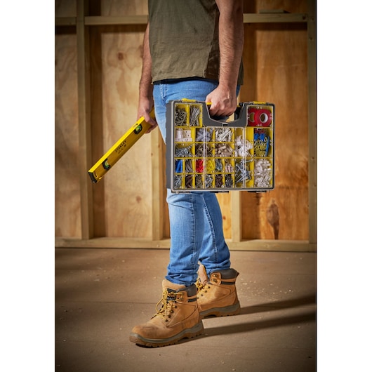 STANLEY 1-92-748 organizer box with assorted fasteners, carried beside yellow level tool at construction site.