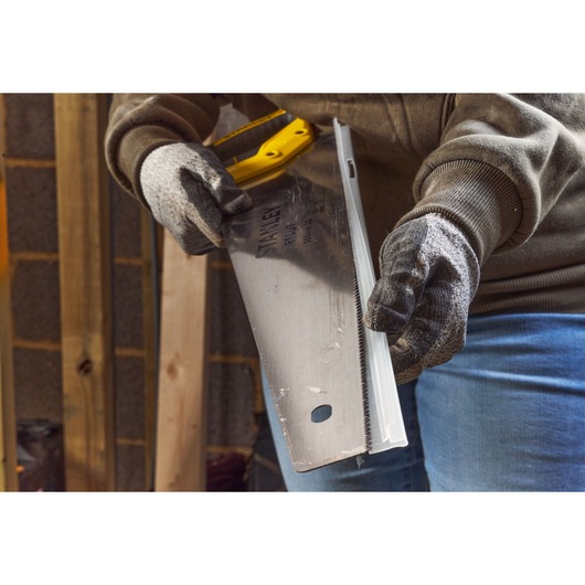 STANLEY 2-15-244 hand saw being used with gloves in a workshop, close-up angle.
