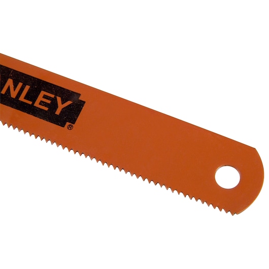 Close-up of the serrated edge and hole of an orange Stanley saw blade.