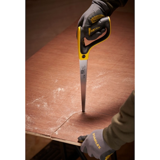 STANLEY 2-17-205 handsaw cutting plywood, close-up photo with gloved hands and curved cut.