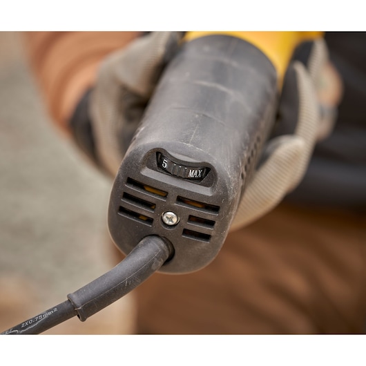 STANLEY FMEG225VS angle grinder with variable speed dial, closeup of rear handle in use.