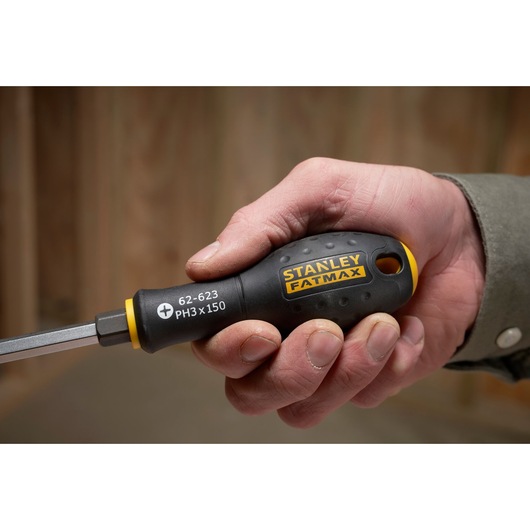 STANLEY FMHT0-62623 screwdriver with black and yellow handle, FATMAX branding, shown held in a hand.