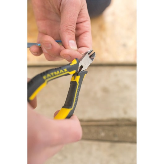 STANLEY FMHT0-80518 diagonal pliers cutting wire, close-up photography of black and yellow tool.