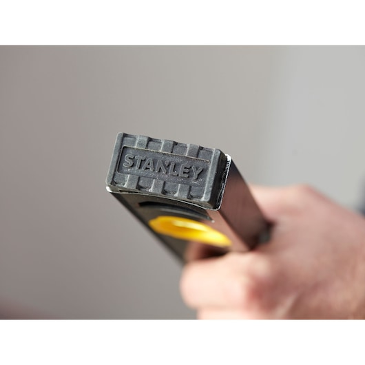 STANLEY FMHT42559-1 spirit level close-up, black and yellow body, hand holding tool.