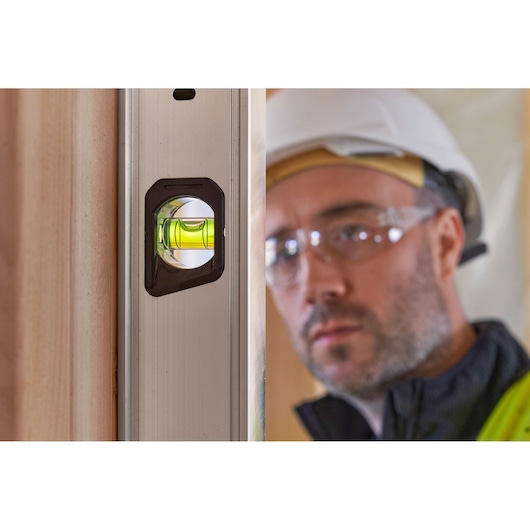 STANLEY FMHT43679-1 aluminum spirit level close-up showing vial in use, construction context.