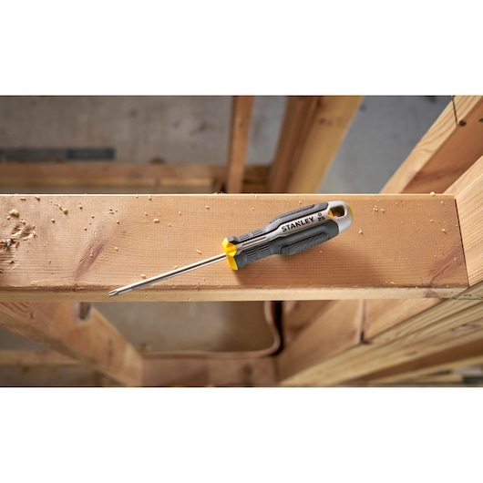 Stanley Phillips screwdriver with a yellow and black handle on a wooden beam.