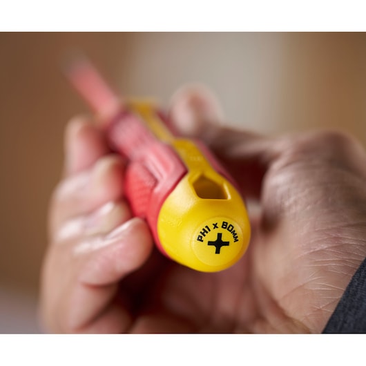Close-up of a hand holding a Stanley insulated screwdriver with yellow and red handle marked PH1 x 80mm.