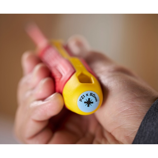 Close-up of hand holding a yellow and red Stanley screwdriver, end labeled PZ1 x 80mm.