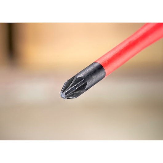 Close-up of a red-handled Phillips screwdriver tip on a blurred background.