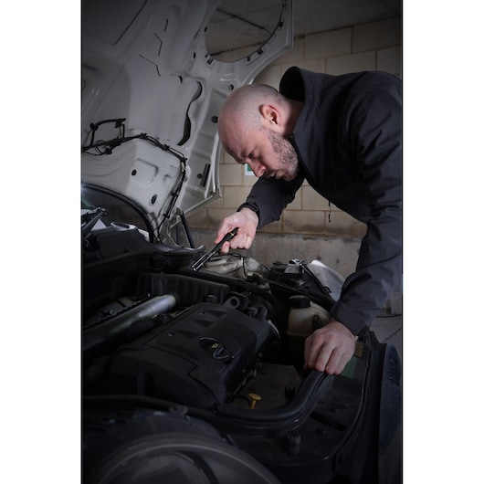 STANLEY FMHT81510-0 inspection tool used by person checking engine under car hood, indoor setting.