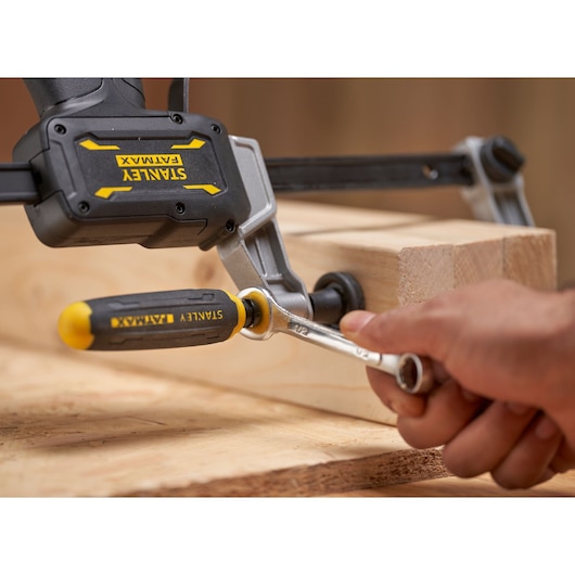 STANLEY FMHT83006-0 FATMAX clamp tool securing wooden boards, close-up side angle.