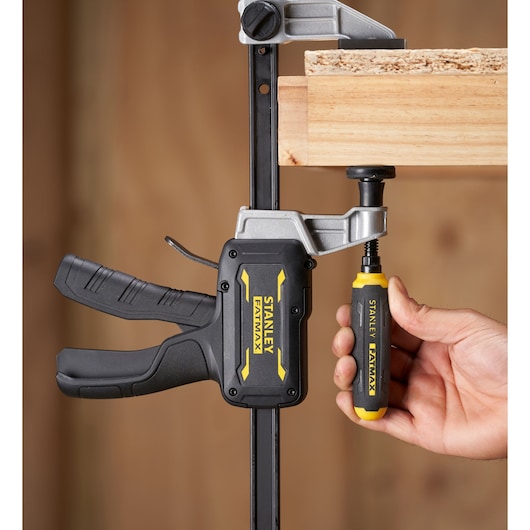 STANLEY FMHT83008-0 FATMAX bar clamp in use, clamping wood, close-up side angle.