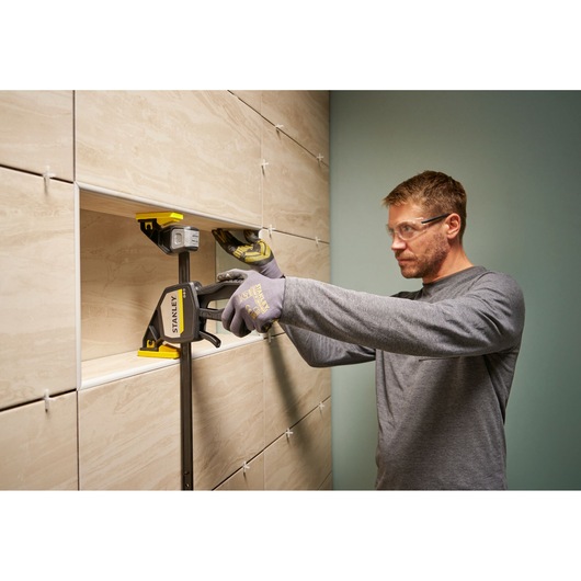 Photo of STANLEY FMHT83279-0 clamp used to hold tiles in place during wall installation.
