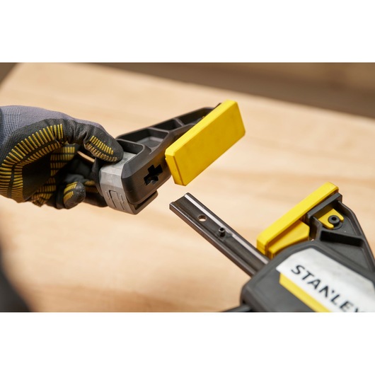 STANLEY FMHT83279-0 photography of clamp with yellow jaw pads, close-up angled view.