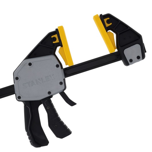 Photo of STANLEY FMHT83283-0 trigger clamp with black, grey and yellow parts, side view.