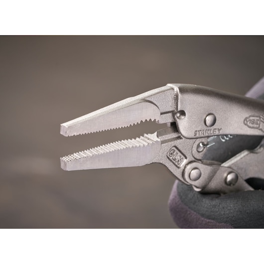 Close-up of a Stanley locking pliers tool with serrated jaws. Metallic finish and detailed mechanism visible.