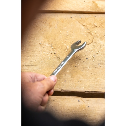 Photo of STANLEY FMMT13041-0 open-end wrench held by hand on wooden surface.