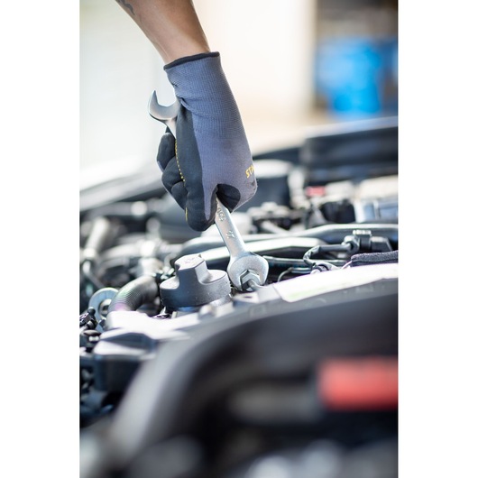 STANLEY FMMT13067-0 wrench used by gloved hand on car engine, close-up photography.
