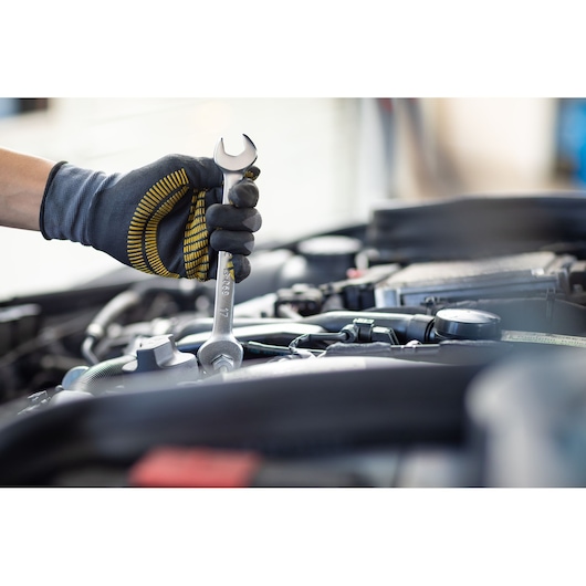 Photo of STANLEY FMMT13067-0 wrench in gloved hand working on car engine.