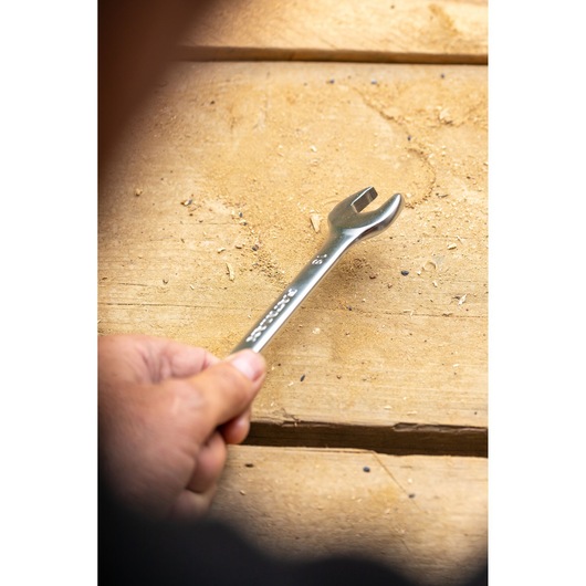 Stanley FMMT13069-0 wrench held by hand, close-up on wooden surface, photography product.