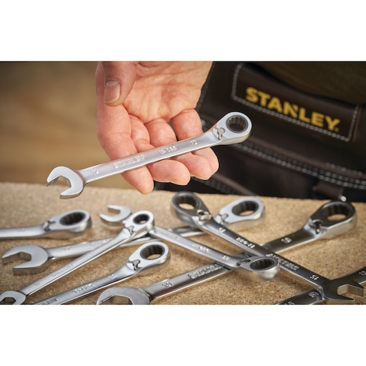 Photo of STANLEY FMMT13081-0 ratcheting wrench set, silver, held in hand with other wrenches on table.