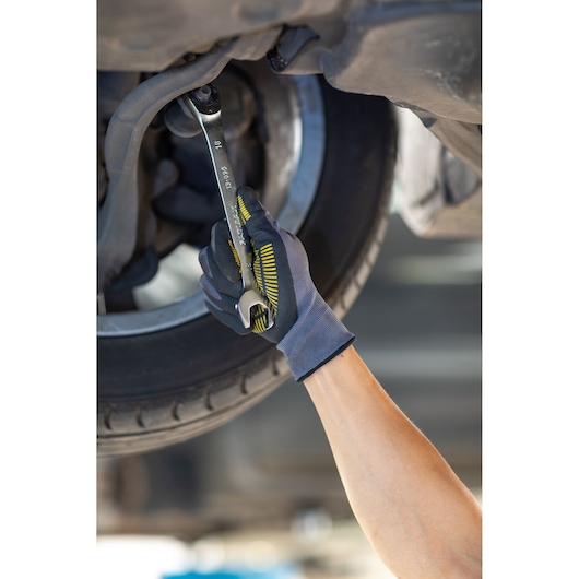 STANLEY FMMT13082-0 wrench used under car by gloved hand, automotive repair photography.
