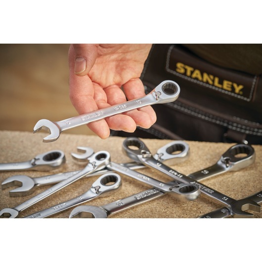 Photo of STANLEY FMMT13087-0 wrench set, silver wrenches on table, one held in hand, close-up angle.