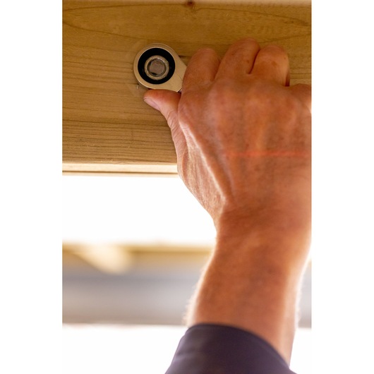 STANLEY FMMT13098-0 ratchet being used on a bolt in wood, close-up, indoor setting.