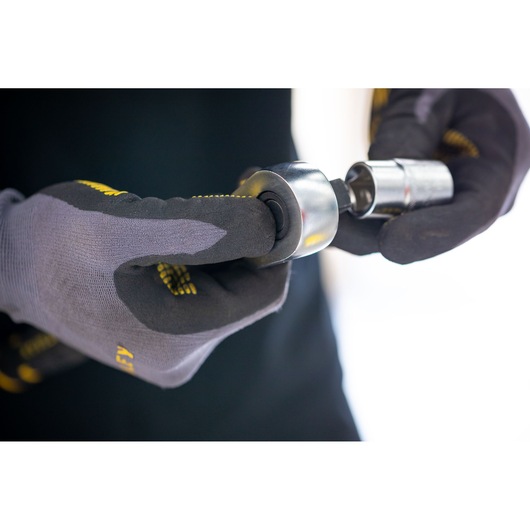 STANLEY FMMT17233-0 socket tool held in gloved hands, close-up photography.