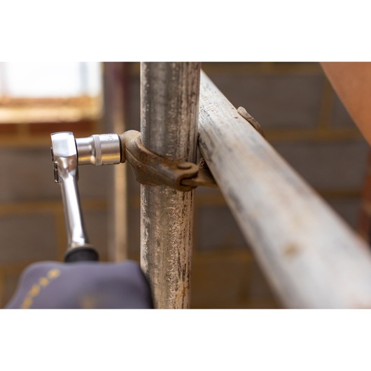 STANLEY FMMT17234-0 ratchet wrench tightening scaffold clamp, tool close-up photography.