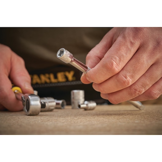 Photo of STANLEY FMMT25126-0 socket wrench set being held and used on a workbench.