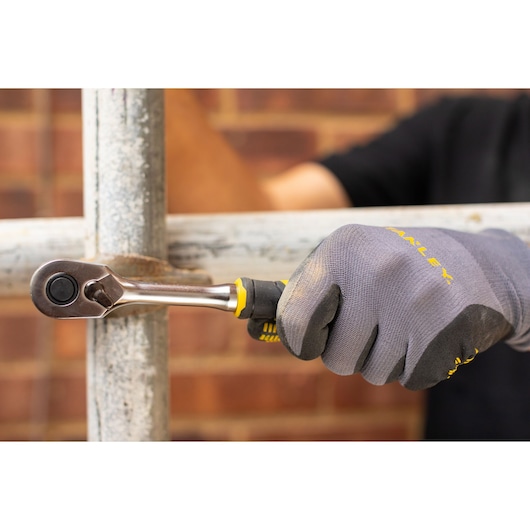 STANLEY FMMT82678-0 ratchet being used on metal pipe, worker wearing grey gloves.