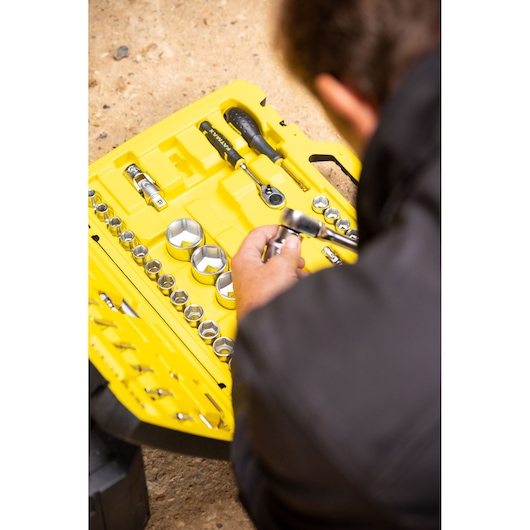 STANLEY FMMT82683-0 socket set in yellow case with various sockets and ratchet, person holding tool.