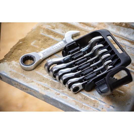 STANLEY FMMT82900-0 ratcheting spanner set in black holder on metal surface with sand, angled outdoor view.