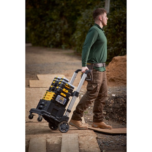 Stanley FMMT98103-1 mobile tool organizer stack on wheeled cart outdoors, carried by worker.