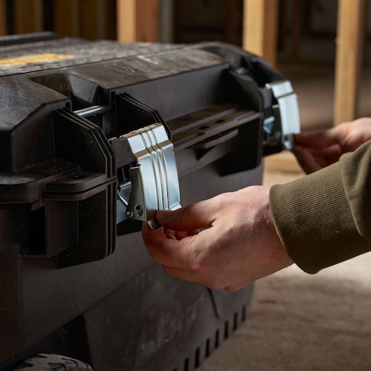 STANLEY FMST1-73601 tool box with metal latches, close-up of hands securing front locks.